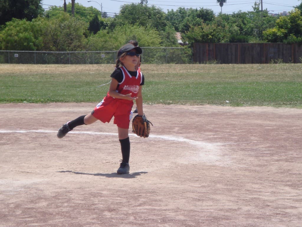 Alaina at 4 years old, pitching on a field
